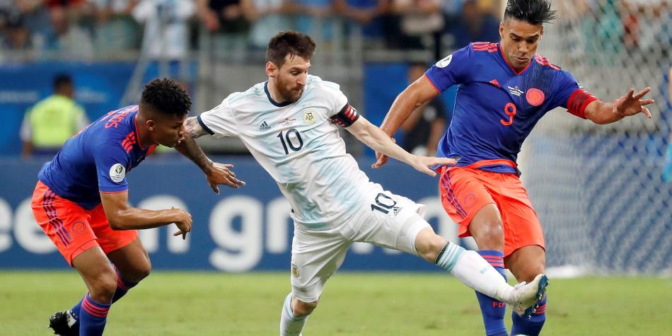 Foto: EFE (2019) – Barrios y Falcao pelean una pelota frente a Messi