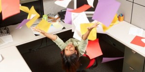 Ecstatic businesswoman throwing office papers