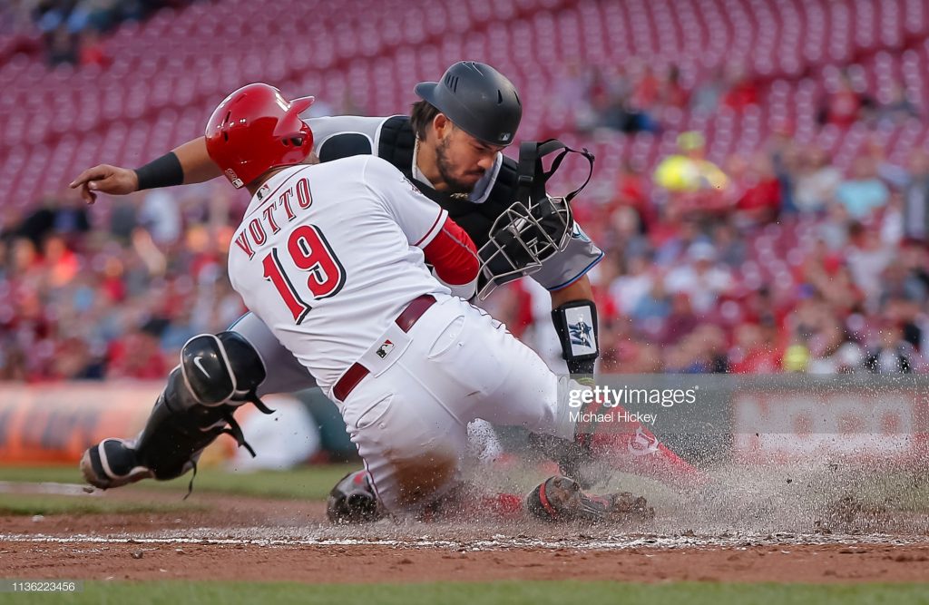CINCINNATI, OH - APRIL 10: Joey Votto #19 of the Cincinnati Reds slides into the tag of Jorge Alfaro #38 of the Miami Marlins at home plate in the first inning at Great American Ball Park on April10, 2019 in Cincinnati, Ohio. (Photo by Michael Hickey/Getty Images)