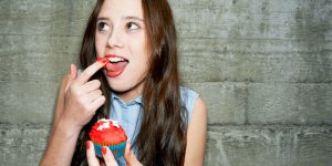 landscape-1464278687-young-woman-eating-cupcake