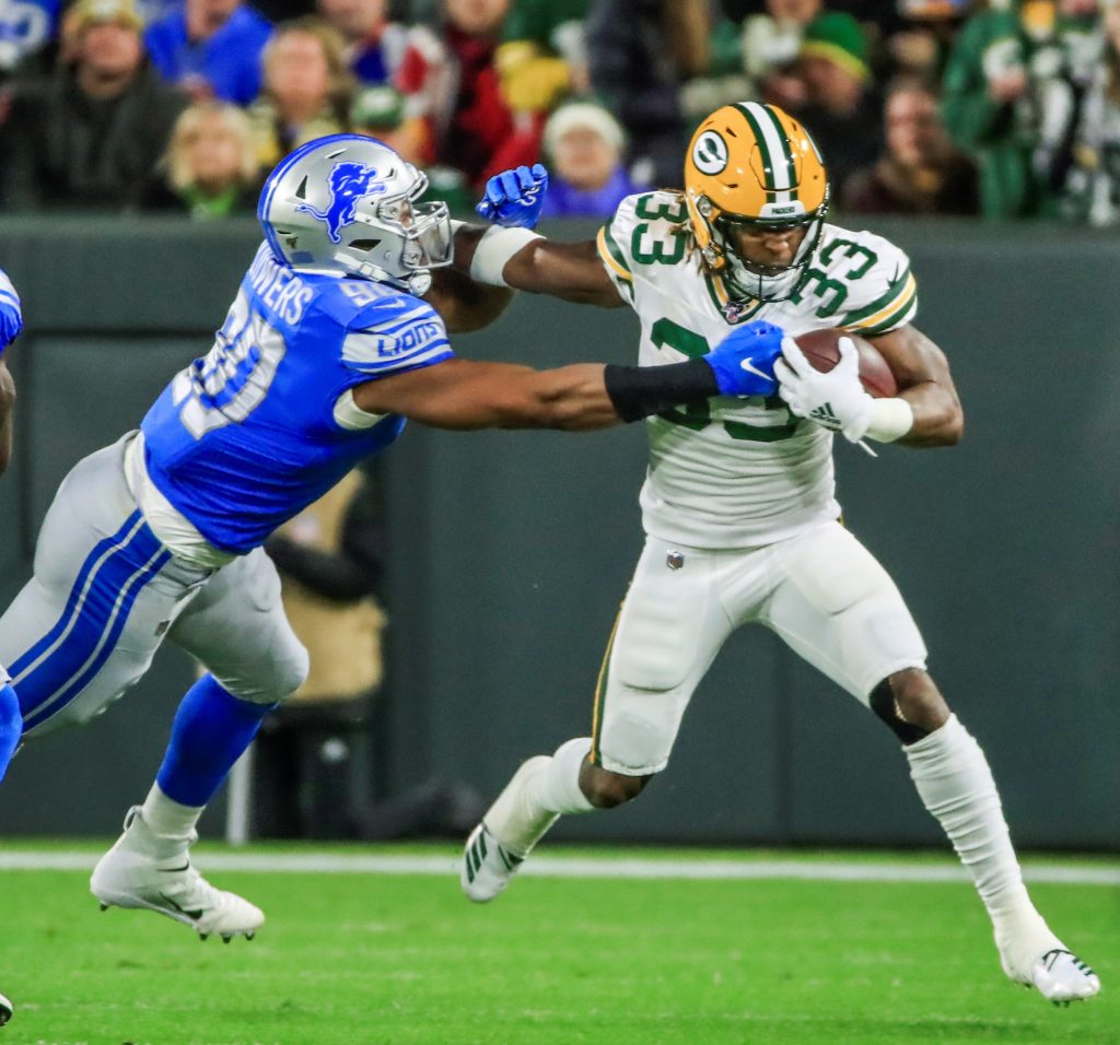 El defensivo de los Lions Trey Flowers intenta derribar al corredor de los Packers Aaron Jones. Foto: EFE