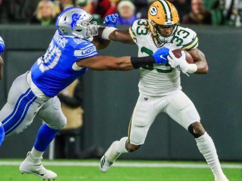 El defensivo de los Lions Trey Flowers intenta derribar al corredor de los Packers Aaron Jones. Foto: EFE