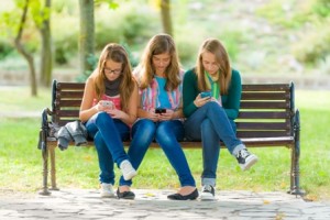 Teen girls using their mobile phones