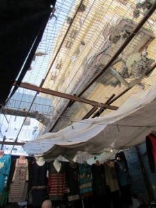 Colonos israelies lanzan basura al mercado palestino en Hebrón desde arriba.