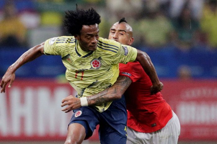 Juan Guillermo Cuadrado enfrenta un balón con Arturo Vidal. Foto: Reuters