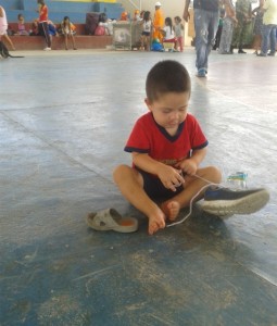 Este pequeño juega a aprender a amarrar sus zapatos, en uno de los albergues de Cúcuta. 